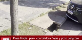 Plaza limpia pero con baldosa flojas y pozo peligroso
